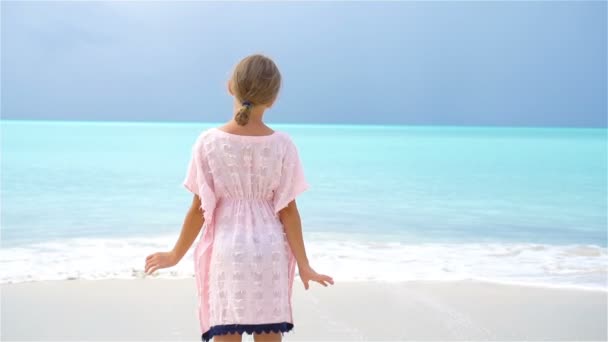 Очаровательная маленькая девочка весело провести время на тропическом пляже во время отпуска. Медленное движение — стоковое видео