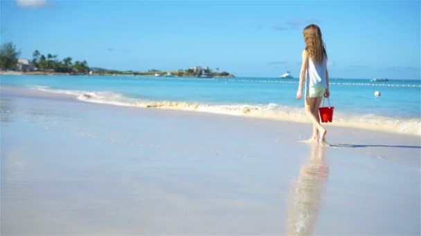 Чарівна маленька дівчинка гуляє на пляжі — стокове відео