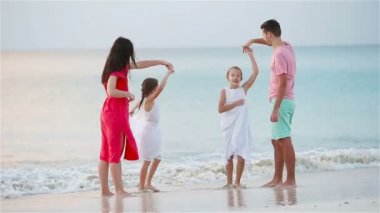 Mutlu güzel bir aile beyaz sahilde eğleniyor