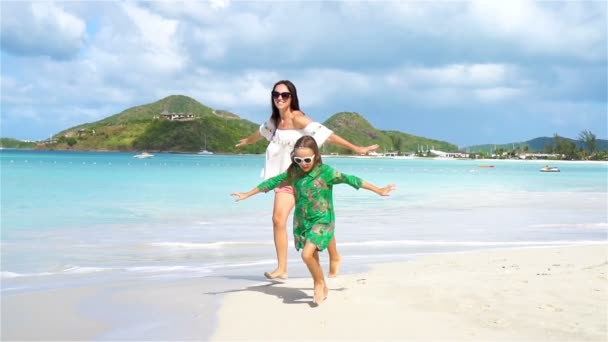 Aile Eğlence beyaz kum üzerinde. Anne ve güneşli bir günde kumlu plajda oynayan sevimli çocuk gülümseyen. Ağır çekim — Stok video