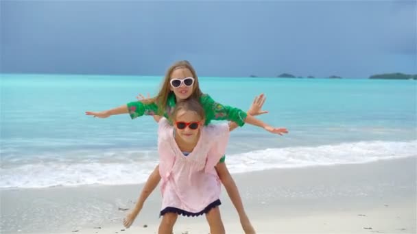 Küçük sevimli kız tropikal plaj birlikte oynarken eğleniyor. Ağır çekim — Stok video