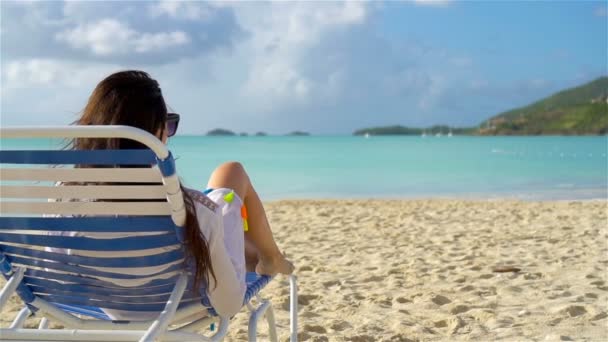 Relajarse y disfrutar en las vacaciones de verano, mujer tumbada en la cama de sol en la playa. MOCIÓN LENTA — Vídeos de Stock