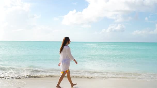 Молодая красивая женщина весело провести время на й пляже. Вид сзади на девушку на побережье Карибского моря. Медленное движение — стоковое видео