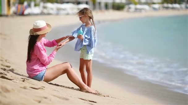 Mladá matka použití sluneční krém pro kid ruku venku na tropické pláži — Stock video