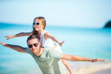 Küçük kız ve mutlu baba kumsal tatili boyunca eğleniyorlar.