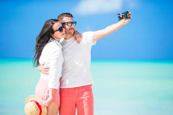 Pareja feliz tomando una foto selfie en la playa blanca. Dos adultos disfrutando de sus vacaciones en la playa tropical exótica — Foto de Stock