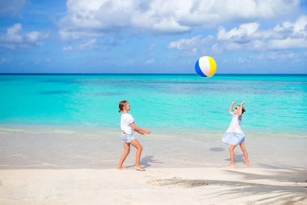 Маленькие очаровательные девочки играют с мячом на пляже — стоковое фото
