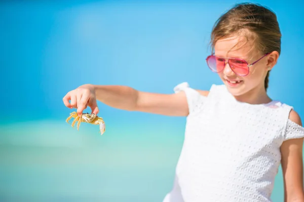 Entzückendes kleines Mädchen mit Krabbe am Strand — Stockfoto