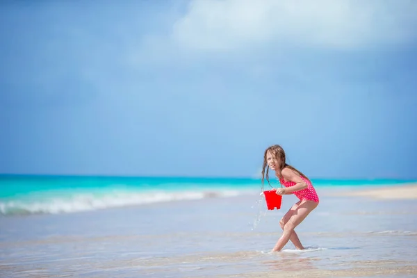 Rozkošná holčička hraje s hračkami beach v mělké vodě — Stock fotografie