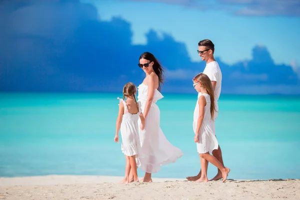 Семья из четырех человек ходит по белому пляжу — стоковое фото