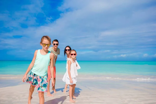 Happy family of four on white beach — Stock Photo, Image