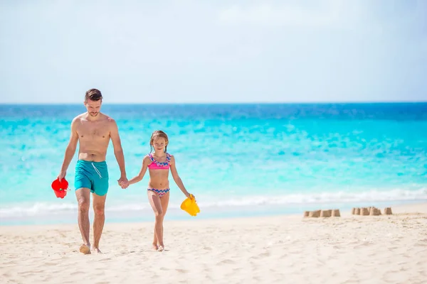 Маленькая девочка и счастливый папа играют на пляже — стоковое фото