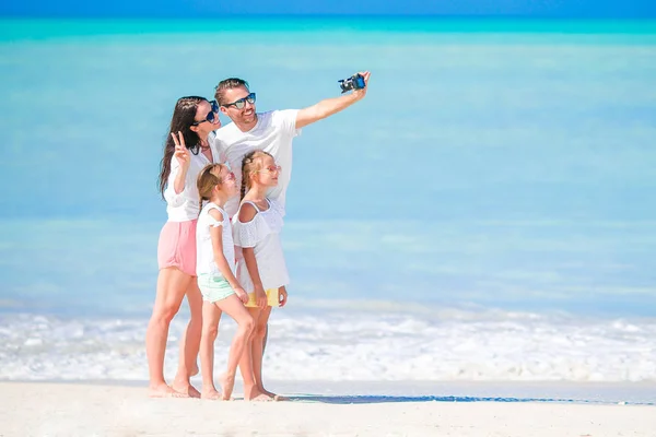 Un hombre tomando una foto de su familia en la playa. Vacaciones familiares — Foto de Stock