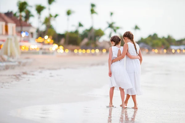 Rear view of little beautiful girls walking on tropical seashore — Stock Photo, Image
