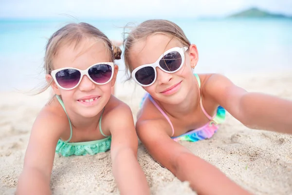 Zblízka holčičky na písečné pláži. Šťastné děti ležící na teplé bílé písečné pláži — Stock fotografie