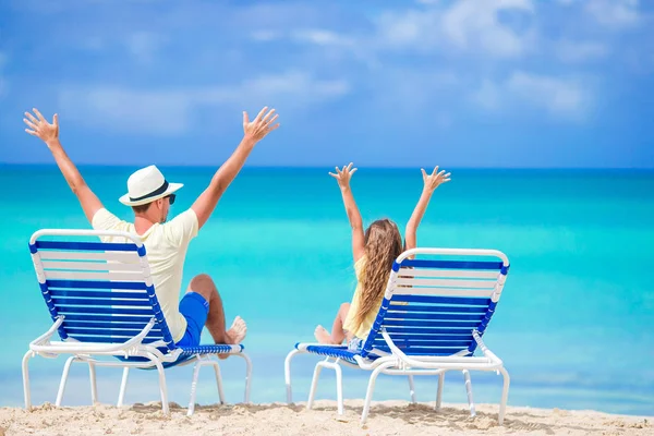 Padre e hija manos arriba en la playa sentados en chaise-longue — Foto de Stock