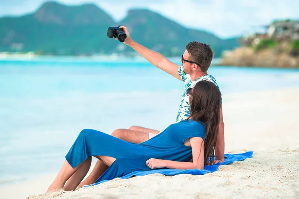 Šťastný pár fotografování selfie na bílé pláži. Dva dospělí užívat jejich dovolené na tropické pláži exotické — Stock fotografie
