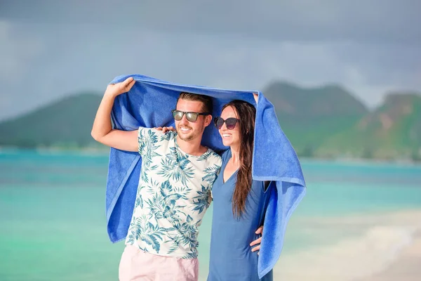 Genç aile iki havlu ile tropik sahilde. Uzak tropikal plajları ve ülkeler. Seyahat kavramı — Stok fotoğraf