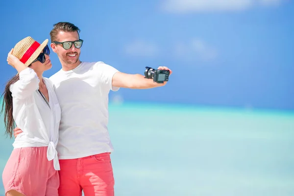 Pareja feliz tomando una foto selfie en la playa blanca. Dos adultos disfrutando de sus vacaciones en la playa tropical exótica — Foto de Stock