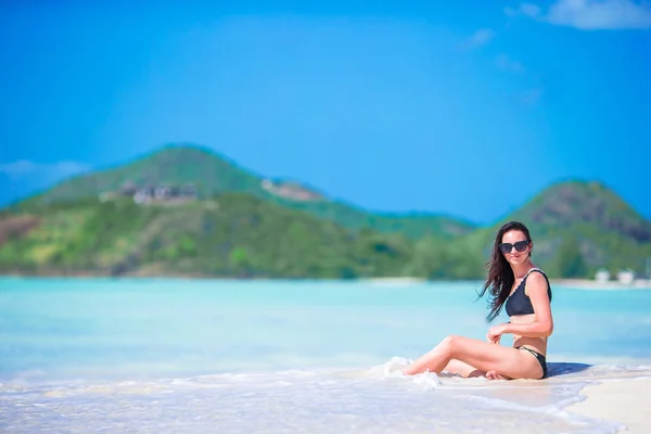 Joven hermosa mujer divirtiéndose en la orilla del mar tropical. Chica feliz en la playa tropical de arena blanca —  Fotos de Stock