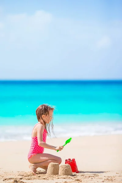 Beyaz tropial plajda plaj oyuncaklarıyla oynayan sevimli küçük kız. — Stok fotoğraf