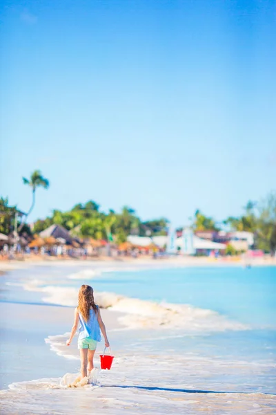 Adorable niña jugando con juguetes de playa en la playa tropial blanca —  Fotos de Stock