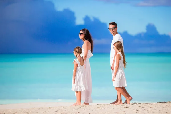 Familia de cuatro personas caminando en la playa blanca tropical caribeña —  Fotos de Stock