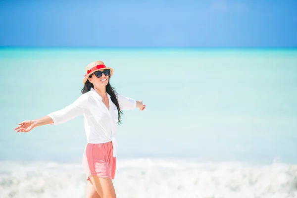 Ung vacker kvinna som har roligt på tropisk kust. Lycklig flicka bakgrund den blå himlen och turkost vatten i havet på karibiska ön — Stockfoto