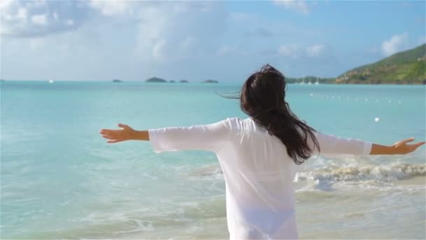 Νεαρή όμορφη γυναίκα διασκέδαση στον τροπικό αιγιαλού. Ευτυχισμένος κορίτσι περπάτημα σε τροπική παραλία με λευκή άμμο. Αργή κίνηση — Αρχείο Βίντεο