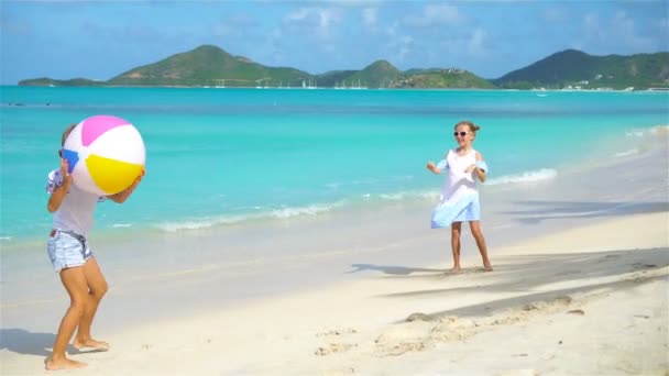 Маленькие очаровательные девочки играют с мячом на пляже . — стоковое видео