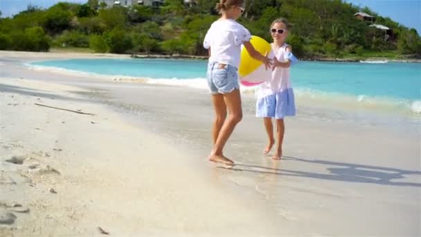 Små bedårande flickor leker med boll på stranden. — Stockvideo