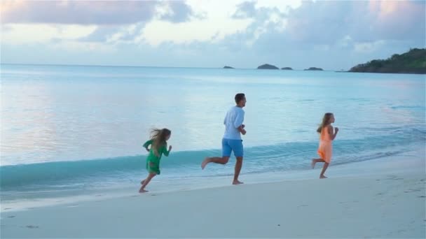 Gelukkige familie van vader en moeder spelen samen op het strand — Stockvideo