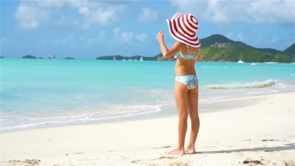 Schattig klein meisje met grote hoed op het strand — Stockvideo