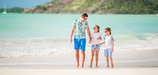 Mladý otec a její rozkošné malé dcery na pláži — Stock fotografie