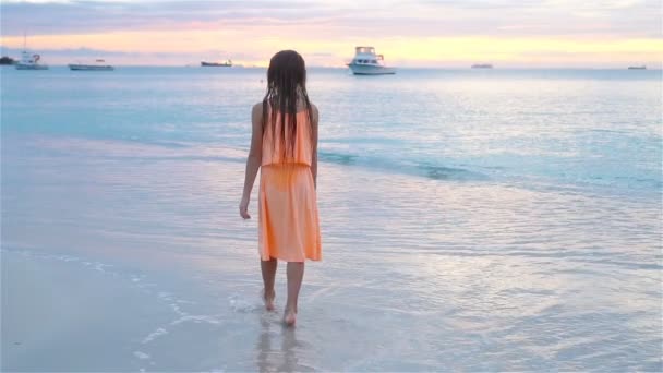 Adorável menina feliz andando na praia branca ao pôr-do-sol. SLOW MOTION VIDEO — Vídeo de Stock