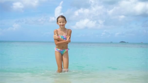 Adorable little girl on the beach. Happy kid enjoy summer vacation — Stock Video