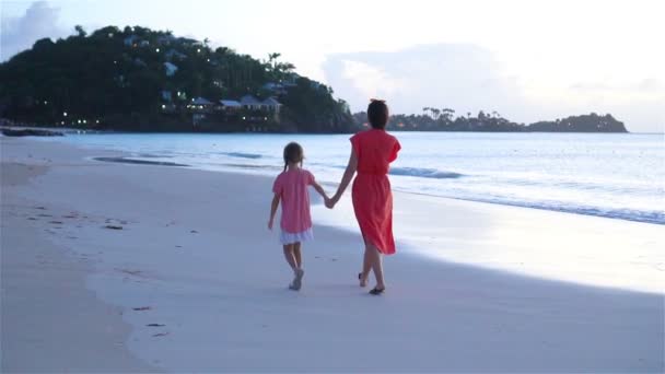 Beautiful mother and daughter on Caribbean beach. Family on beach vacation. SLOW MOTION