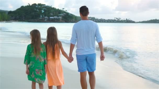 Vader en kinderen genieten van het tropische strand-zomervakantie. Familie wandeling door de zee. Slow Motion — Stockvideo