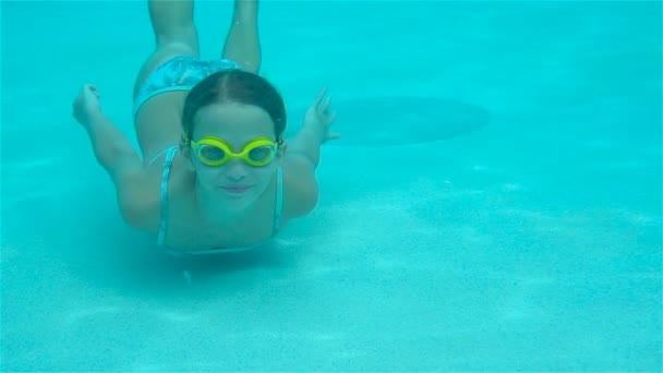 La niña en la piscina bajo el agua y sonriendo — Vídeo de stock