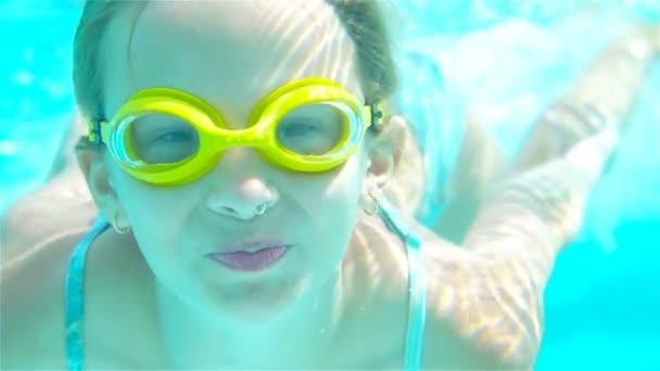 La niña en la piscina bajo el agua y sonriendo — Vídeos de Stock