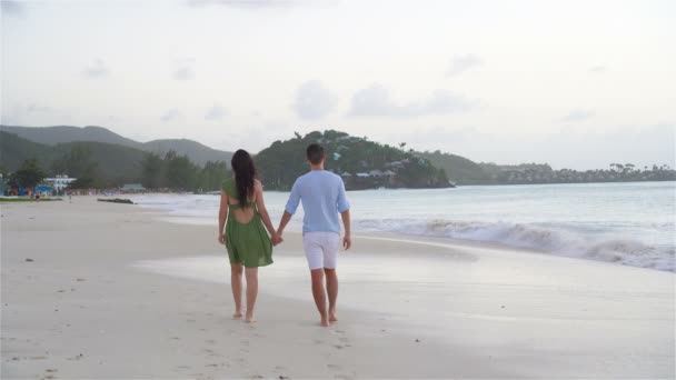 Junges Paar am tropischen Strand mit weißem Sand und türkisfarbenem Meerwasser auf der Karibikinsel Antigua — Stockvideo