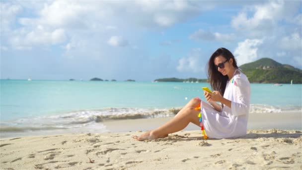 열 대 해변에서 휴가중에 스마트폰을 가진 젊은 여성. 카리 뱅 섬에서 핸드폰을 들고 해변에 있는 아름다운 소녀. — 비디오