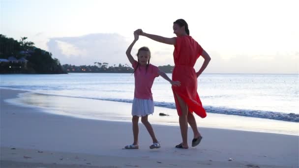 Schöne Mutter und Tochter am karibischen Strand, die Spaß im Sonnenuntergang haben. Familie im Strandurlaub. Zeitlupe — Stockvideo