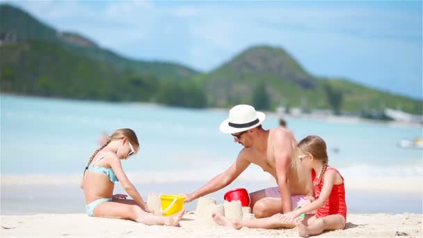 Família fazendo castelo de areia na praia branca tropical . — Vídeo de Stock