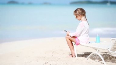 Küçük kız yapma video veya şezlong üzerinde oturan onun kamera ile fotoğraf