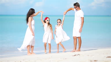 Genç aile beyaz tropikal Karayipler kumsalda eğleniyor
