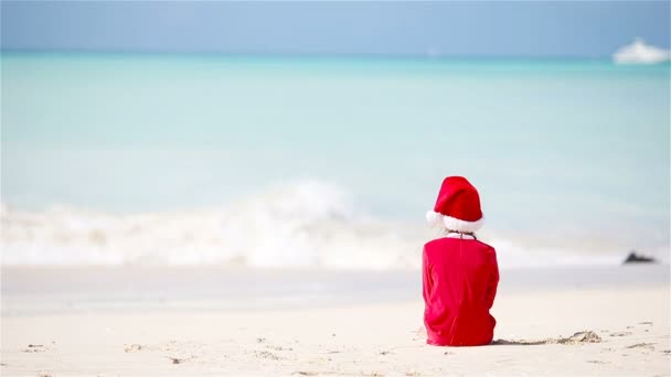 Lilla bedårande flicka i jul hatt på stranden under Xmas semester — Stockvideo