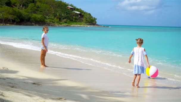 Kleine schattige meisjes spelen met lucht bal op het strand. Gelukkige jonge geitjes genieten van vakantie — Stockvideo