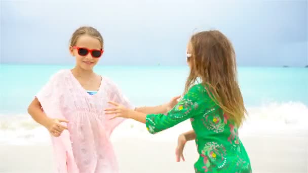 Маленькі дівчата розважаються на тропічному пляжі під час літніх канікул, граючи разом — стокове відео