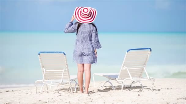 Jonge mooie vrouw op wit zand tropisch strand. Achteraanzicht van Kaukasisch meisje in hoed achtergrond de zee — Stockvideo